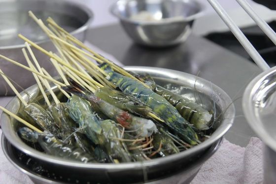 Ghim chặt tôm vào từng xiên que tre